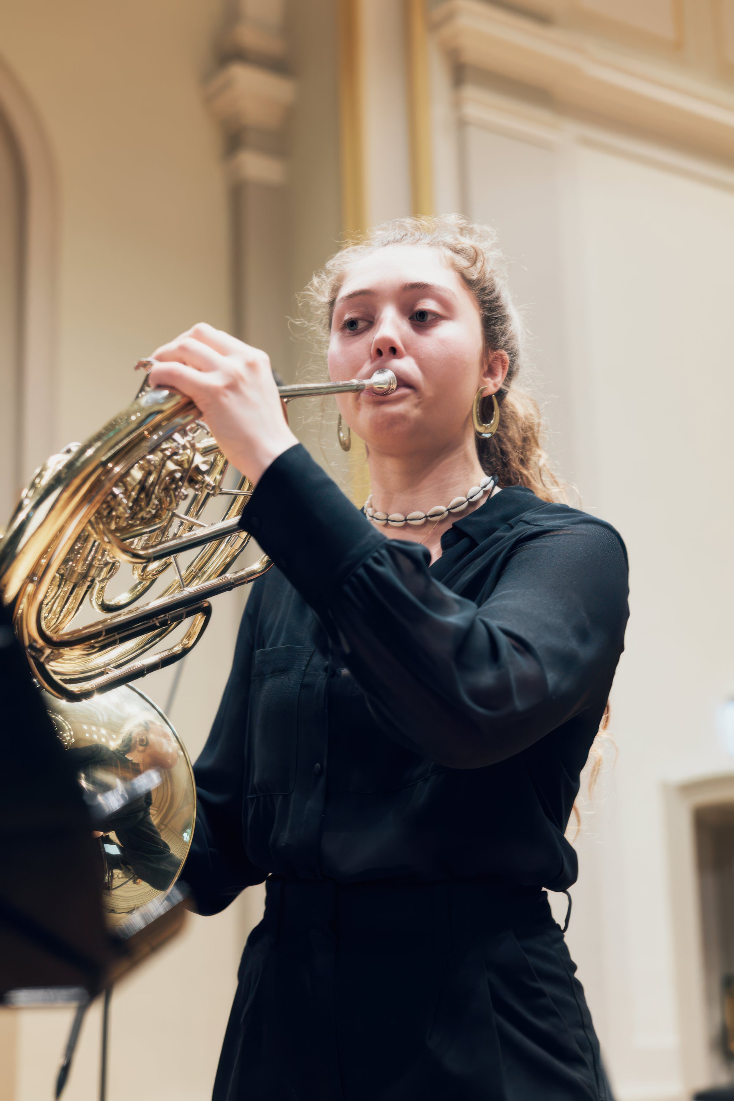 A young horn player performing.