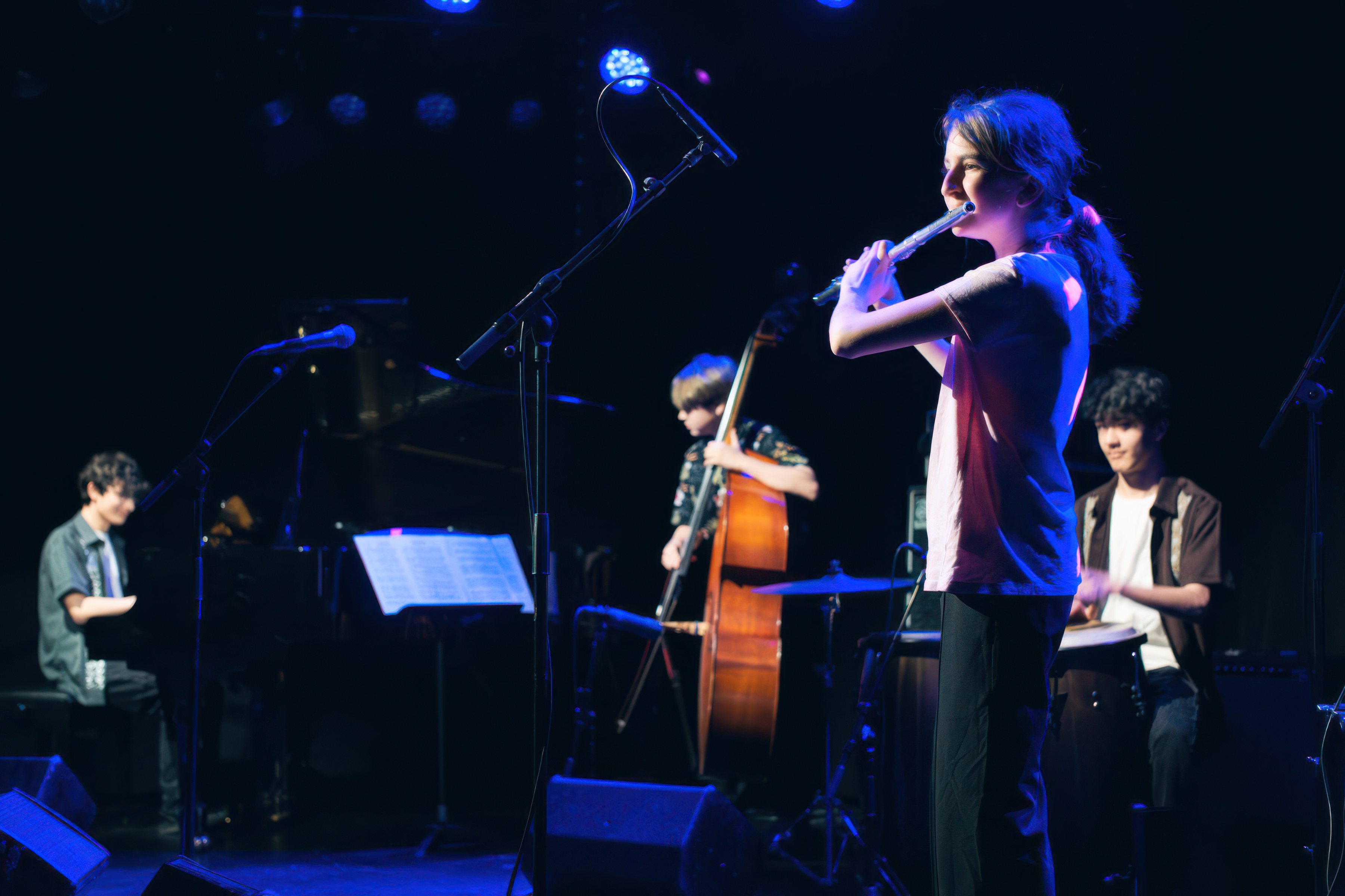 A flautist with double bass and piano.